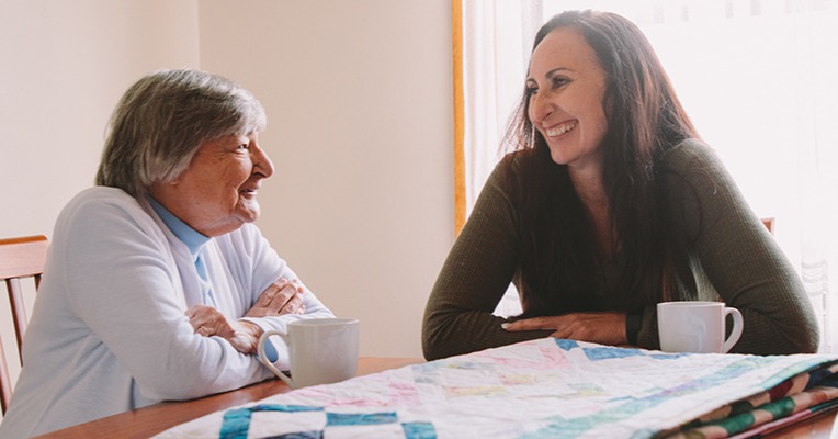 A carer sits in conversation with client Fay