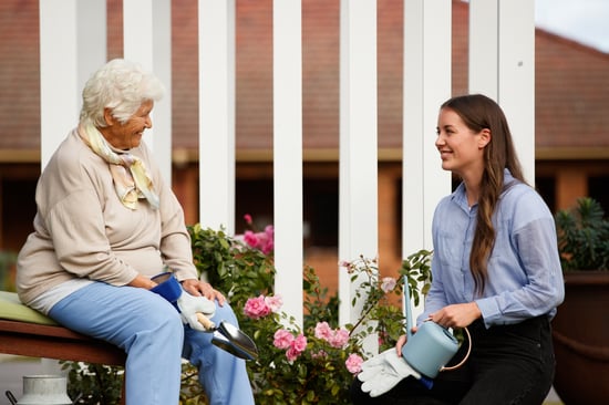 An older woman enjoys pet therapy at HammondCare Horsley, an aged care home near Wollongong, NSW.