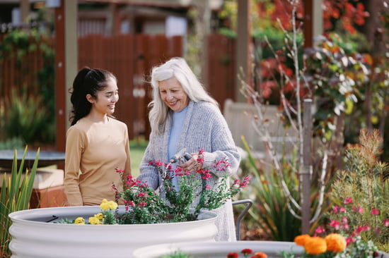 A woman and a carer walk through the garden at HammondCare Daw Park, an aged care home in Adelaide.